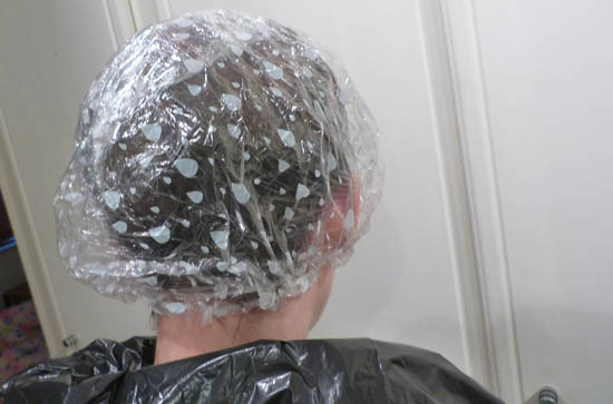 hair wrapped in clingfilm and a showercap