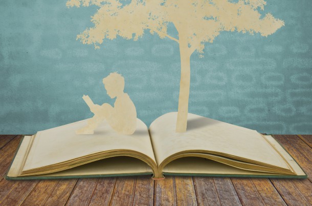 Paper cut of children read a book under tree on old book