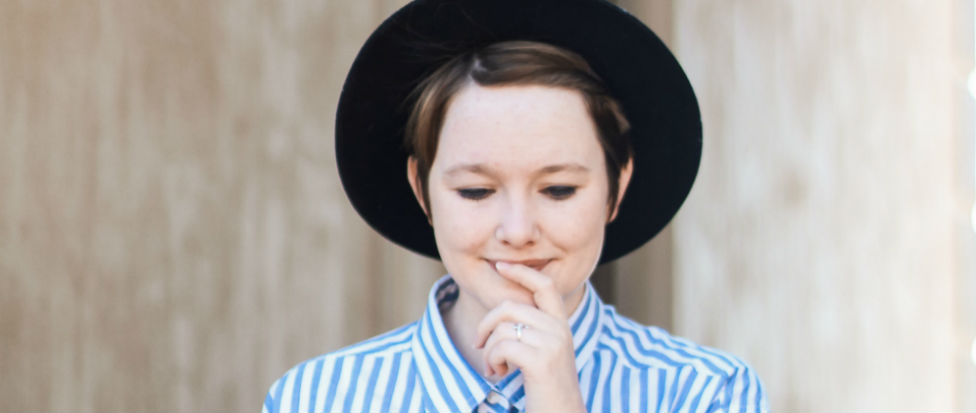 woman in blue and white striped shirt and black hat