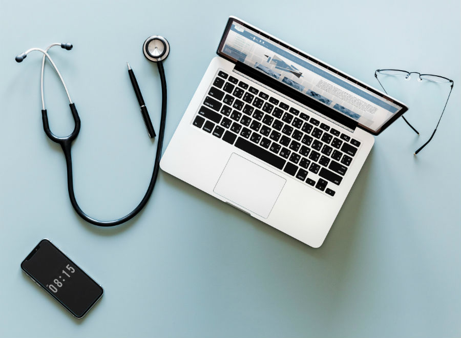 phone stethoscope laptop glasses flatlay