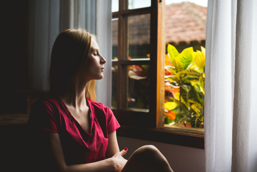 woman eyes closed positioned towards window